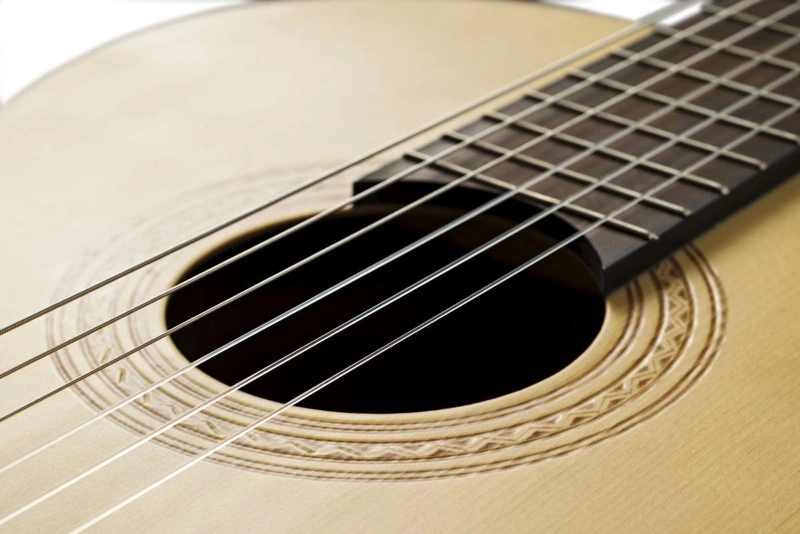 Close-up van het klankgat van een akoestische gitaar.